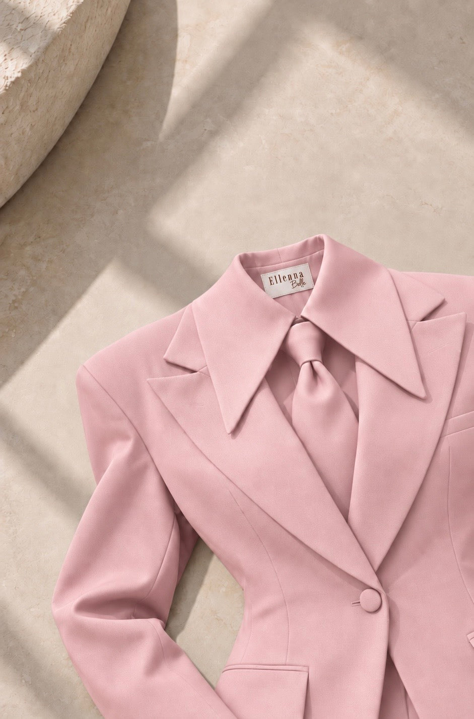 Close-up detail of the Ellenna Belle Her Power Suit in light pink, showing the structured shoulder, collar and tie.